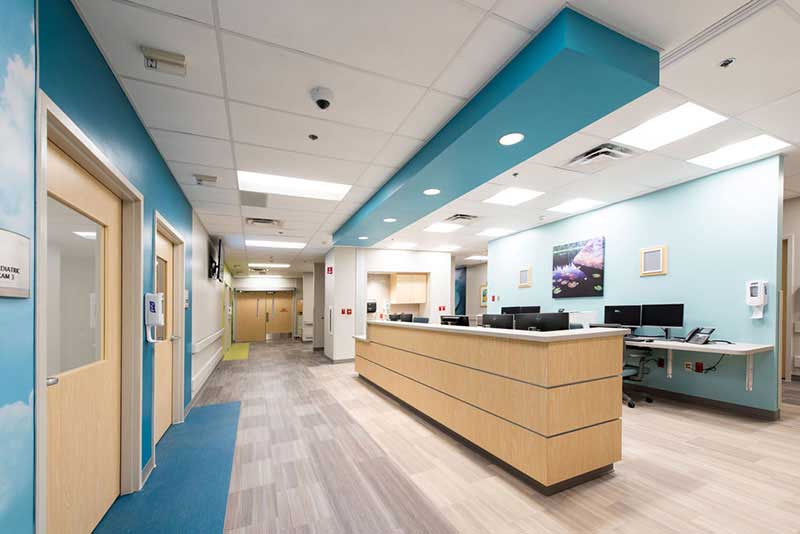 a wide hospital hallway with a reception area
