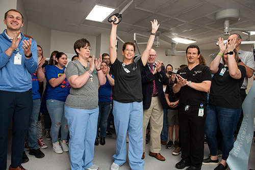 Staff raise their arms in celebration after ribbon cutting ceremony
